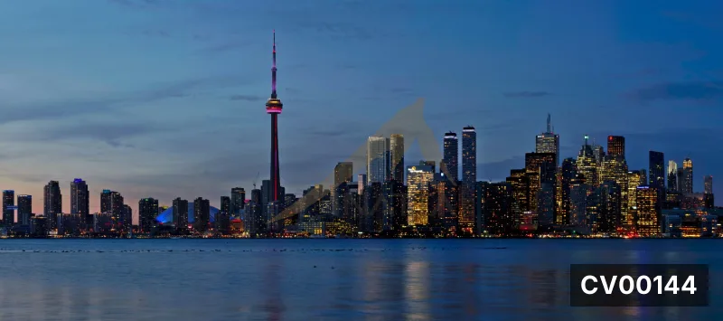 Bờ hồ phía trước thành phố Toronto, tháp CN cao vút giữa các tòa nhà sáng đèn, hồ nước phẳng phản chiếu ánh đèn.
