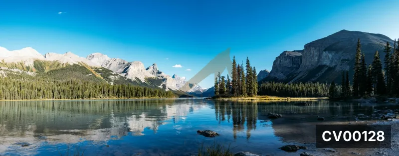 Ảnh chụp panorama hồ nước trong xanh phản chiếu dãy núi đá hùng vĩ và rừng thông dưới bầu trời xanh rực rỡ.